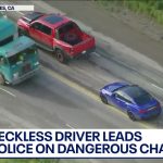 Aerial view of high-speed police chase on highway.