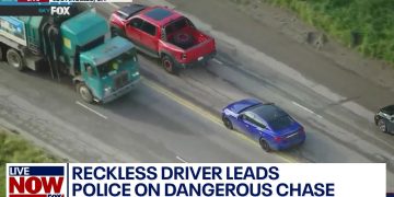 Aerial view of high-speed police chase on highway.