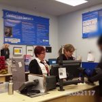 Customer service desk with staff and customer.