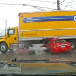 Truck crashed into red car at intersection.