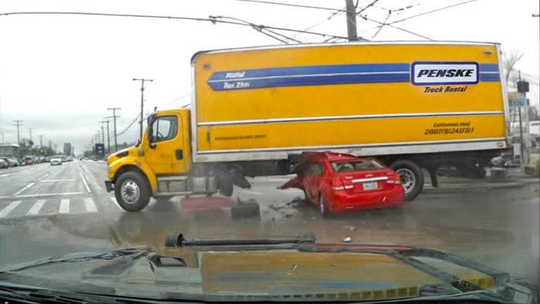 Truck crashed into red car at intersection.