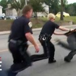 Police officers arresting a fleeing suspect on street.