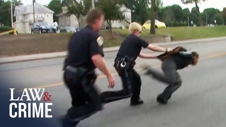 Police officers arresting a fleeing suspect on street.