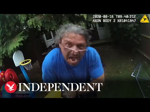 Man confronts police wearing blue shirt, backyard scene.