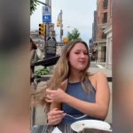 Woman dining outdoors, flipping hair