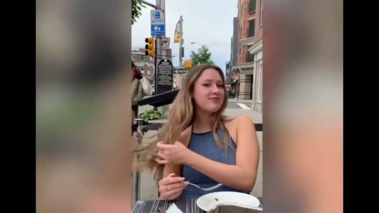 Woman dining outdoors, flipping hair