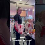 Waitress looking annoyed in a crowded restaurant.