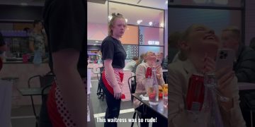 Waitress looking annoyed in a crowded restaurant.