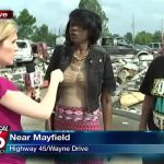 Reporter interviews two people near Mayfield debris site.