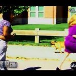 Two women running outside with small dog following.