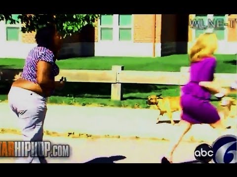 Two women running outside with small dog following.