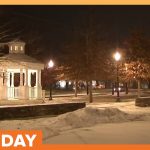 Snowy park with illuminated gazebo at night