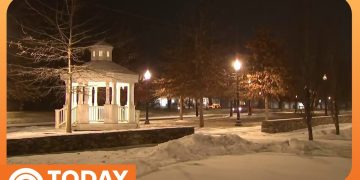 Snowy park with illuminated gazebo at night