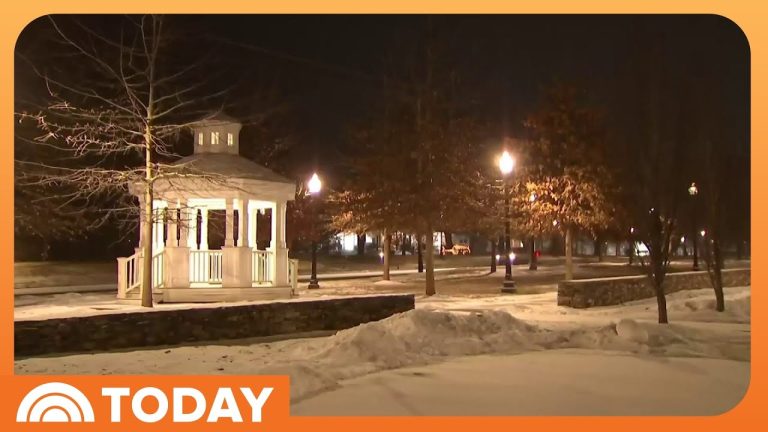 Snowy park with illuminated gazebo at night