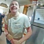 Woman in kitchen with police officer nearby