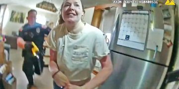 Woman in kitchen with police officer nearby