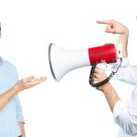 Man smiling at another man with megaphone