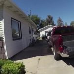 Driveway with parked pickup truck and nearby houses.