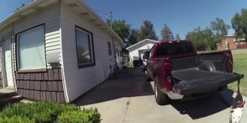 Driveway with parked pickup truck and nearby houses.