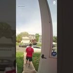 Person leaving house wearing a red sports jersey.