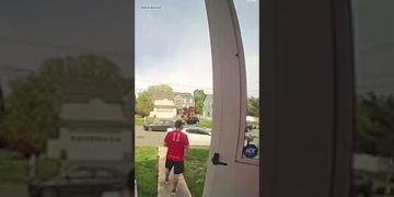 Person leaving house wearing a red sports jersey.