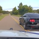 Black sports car driving on rural road