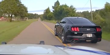 Black sports car driving on rural road