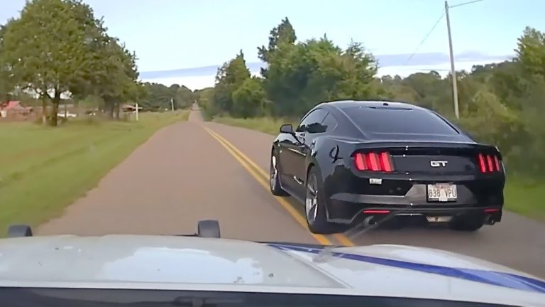 Black sports car driving on rural road