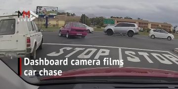 Dashcam captures intersection car chase scene.