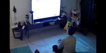 Person playing video game on TV in living room.