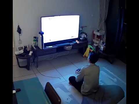 Person playing video game on TV in living room.