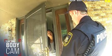 Police officer talking to woman at door