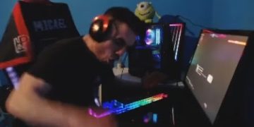 Gamer enthusiastically playing on RGB-lit computer setup