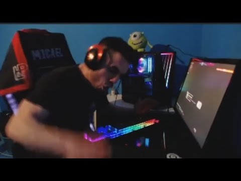 Gamer enthusiastically playing on RGB-lit computer setup