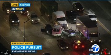 Police pursuit on highway with traffic jam, aerial view.