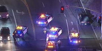 Police cars blocking intersection at night