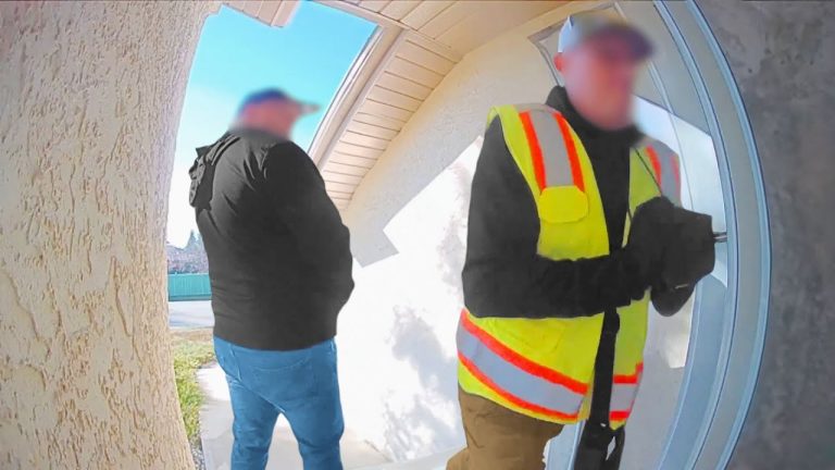 Two men at door, one in safety vest.