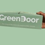 Hand holding GreenDoor box with Aristotle quote.