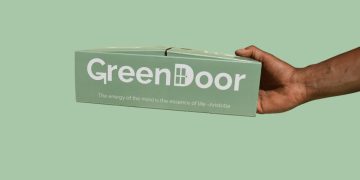 Hand holding GreenDoor box with Aristotle quote.