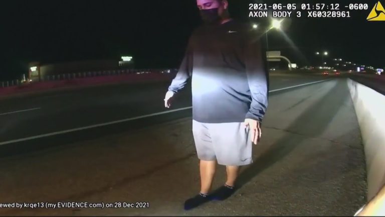 Person walking on road shoulder at night recorded by dashcam