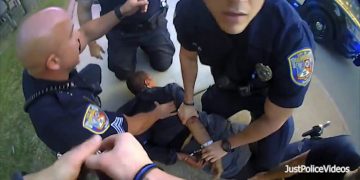 Police officers restraining suspect on ground