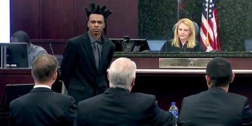 Courtroom scene with judge and defendant standing.