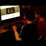 Children playing computer game together at desk.