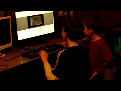 Children playing computer game together at desk.