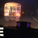 School bus driving at night on rural road.