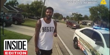 Man standing near police car on street