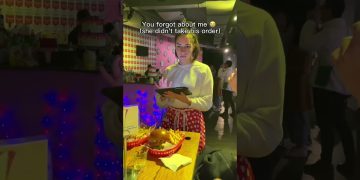 Waitress with tablet beside burger and fries on table