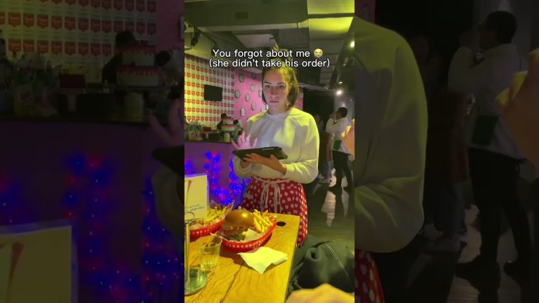 Waitress with tablet beside burger and fries on table