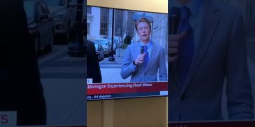 Reporter discussing Michigan heat wave on street