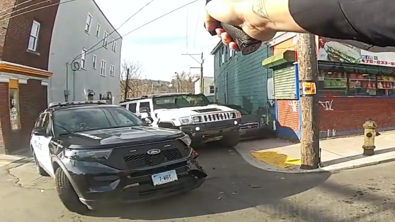 Police car and hand holding taser in street scene.